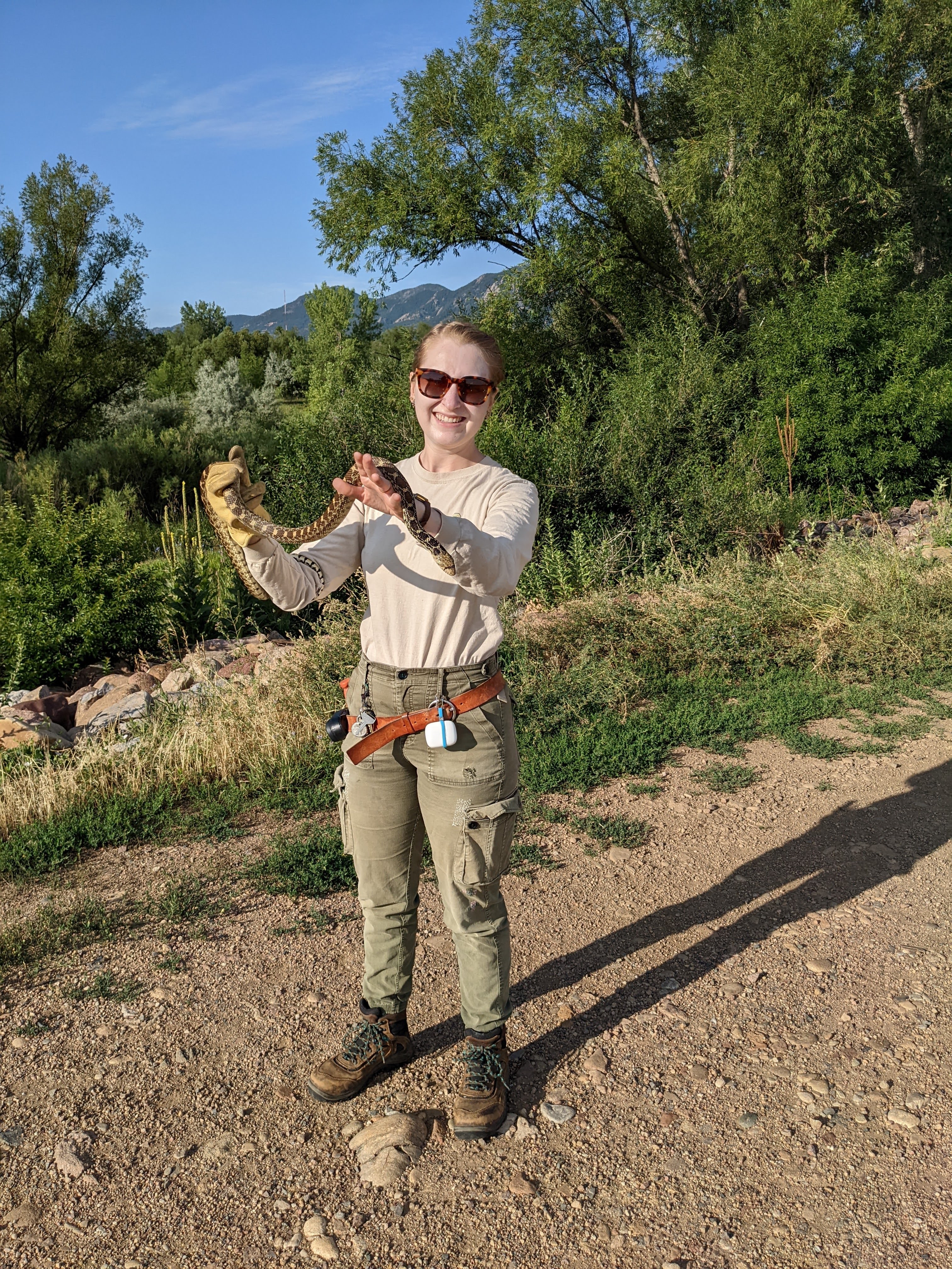 Woman in outdoor wear holding a snake